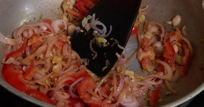 Saut&eacute; frying tossing tomato onion garlic cumin red dry chilli spice in hot oil saucepan cooking for dal tadka bagar 