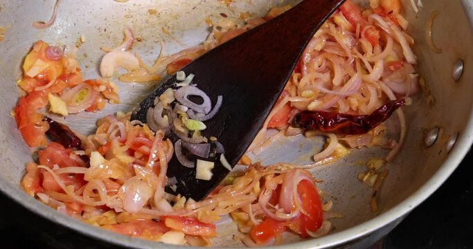 Saut&eacute; frying tossing tomato onion garlic cumin red dry chilli spice in hot oil saucepan cooking for dal tadka bagar 