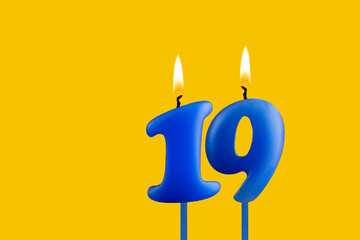 Blue candle number 19 - Birthday on yellow background