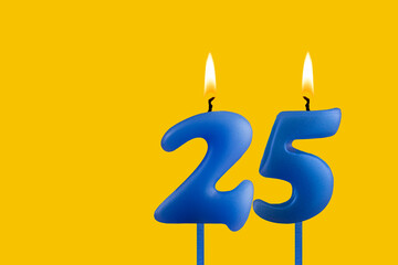 Blue candle number 25 - Birthday on yellow background