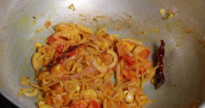 Saut&eacute; frying tossing tomato onion garlic cumin red dry chilli spice in hot oil saucepan cooking for dal tadka bagar 
