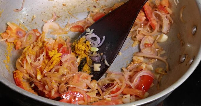 Saut&eacute; frying tossing tomato onion garlic cumin red dry chilli spice in hot oil saucepan cooking for dal tadka bagar 