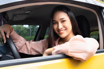 Happy smiling and relaxed woman driver drives with positive emotion, concept image for low reduced gasoline price, good traffic condition, new car, passing driver license, taxi app, Right-side driving