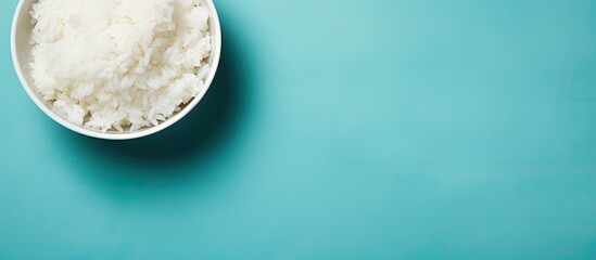 Top view of a bowl of boiled rice on a colorful background providing ample space for text in the...