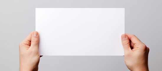 An isolated hand holds a blank paper providing ample copy space for text or images