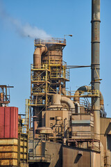 Industrial Facility with Smokestack and Pipes, Clear Sky - Ground Up View