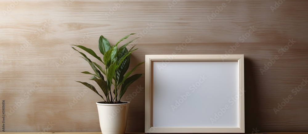 Poster copy space image of a plant and empty photo frame placed on a shelf against a backdrop of a wooden w