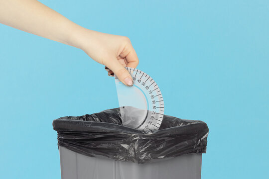 throw protractor in the trash, outstretched arm with protractor in front of trash can, plastic recycling concept