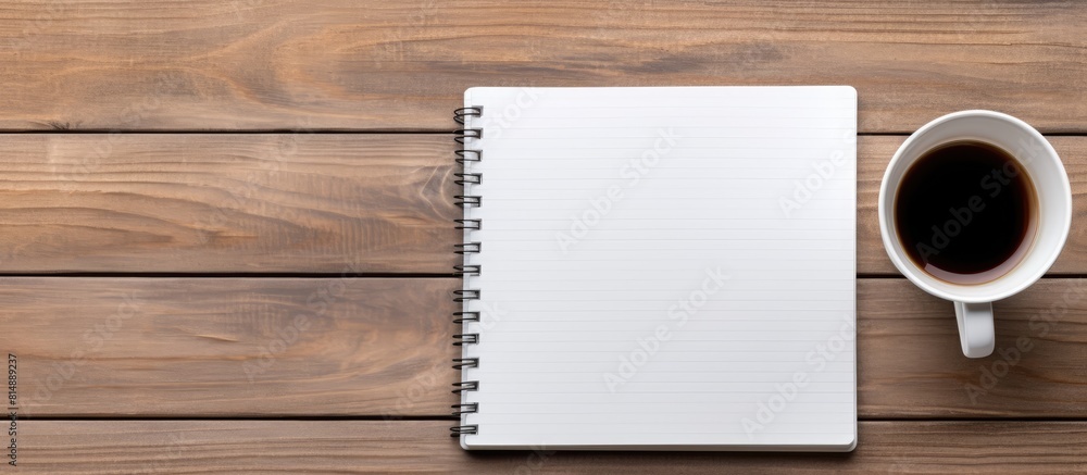 Aufkleber a wooden desk with a blank notebook and office supplies is shown from a top view the image has copy 