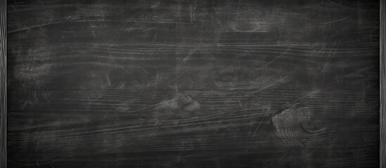 Fototapeta premium A textured blackboard with abstract chalk marks erased providing a clean surface for adding text messages or as a background for a copy space image