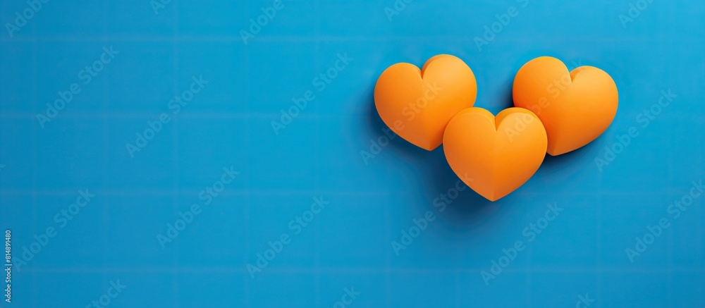 Poster two orange heart shapes are positioned close to each other against a vibrant blue background the ima