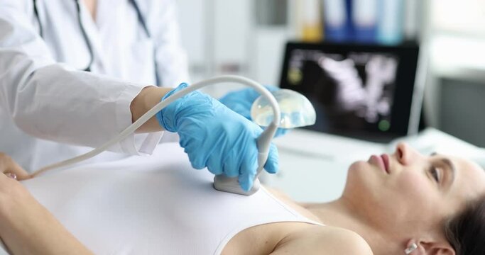 Doctor using ultrasound machine examining a woman chest and heart. Chest ultrasound and first signs of mastitis concept
