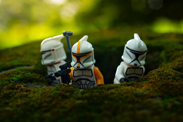 Naklejka premium Depok, Indonesia - May 13, 2024: Lego toys photography, phase 1 clone troopers on a battle in jungle scene recreation, natural outdoor background