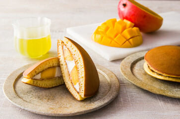 マンゴーとクリームを挟んだどら焼き、緑茶とカットしたマンゴー