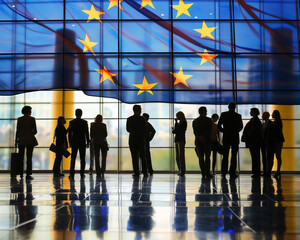 Silhouettes of business people with big EU Flag and big window in the background.