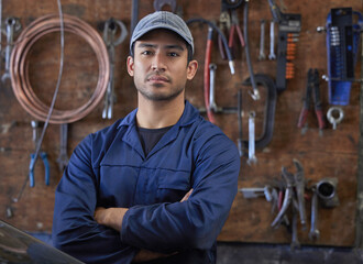 Mechanic, man and portrait in workshop with tools, repair garage and automotive engineering for car maintenance. Professional, vehicle service and motor issues, confident employee and coveralls