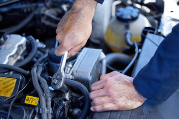 Man, closeup and engine with tools for service in garage, inspection or maintenance on car. Male...
