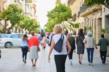 blurred for background. Crowd of people on the street. people walking on the city street. A blurry people walking. Urban, social concept. Abstract urban background with blurred buildings and street.