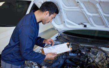 Mechanic, working and clipboard with car engine, checking and automotive engineering service with...