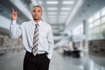 Happy businessman standing at workplace in office