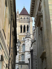 View of the tower of Cathedrale Saint-Pierre Geneve at the end of an alley in Geneva, Switzerland