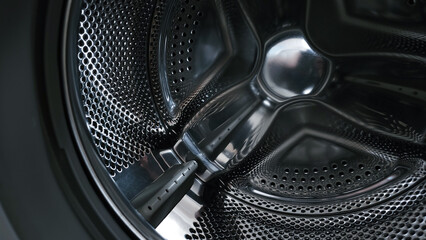 View of a stainless steel drum inside a washing machine