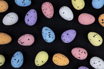Easter eggs on black top view, pattern of Easter eggs