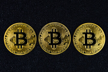 Bitcoin coins on black concrete background top view