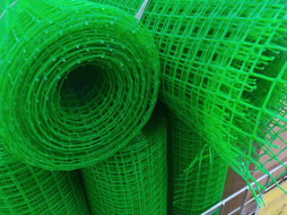 Rolls of green plastic mesh in a hardware store close up