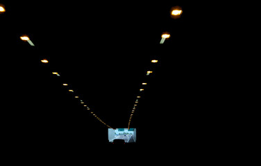 large  highway tunnel with led lights for artificial illumination and a dim light at the end with...