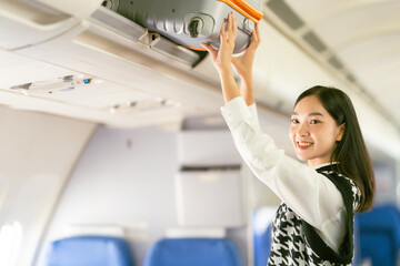 Airplane travel concept: Asian woman looking for a seat on the plane