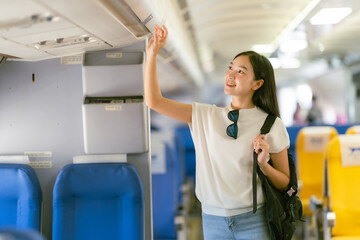 Airplane travel concept: Asian woman looking for a seat on the plane