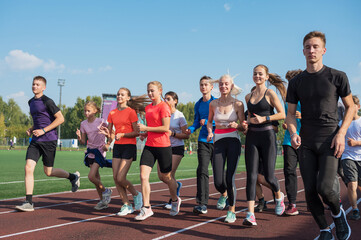 Group of young athletes training at the stadium. School gym trainings or athletics