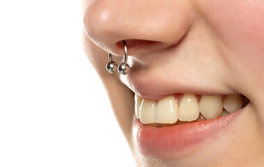 Closeup of a young smiling woman's visage with piercing septum hanging from her nose