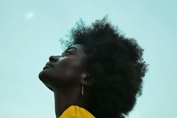 A woman with an afro style looking up into the sky