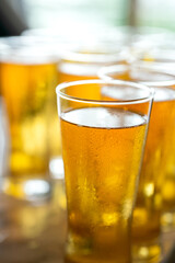 Amber lager beer in glasswares which are prepared for the party event. Refreshment drinking, close-up and selective focus. 