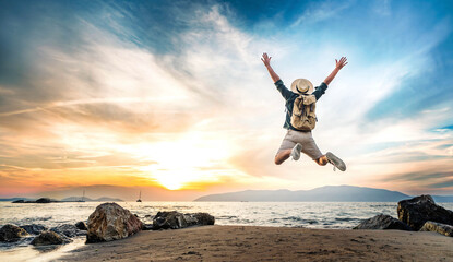 Happy tourist enjoying sunset on the beach - Successful man jumping outside - Summertime holidays...
