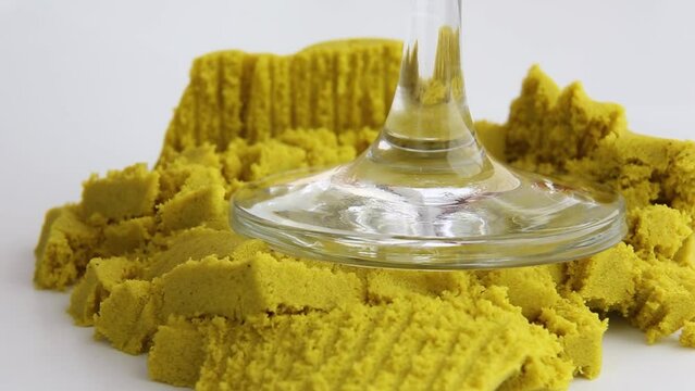 Kinetic sand is crushed with the stem of a glass. ASMR video. Satisfying ASMR videos. Relaxing videos.