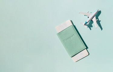 Airplane with passport and tickets on the bright sunny blue background. Summer vacation travel concept.