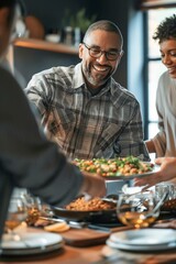 Smiling man serving food to friends at dining table