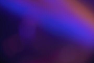 Abstract image with soft undefined shapes of blue and purple colors and blurry rays of light like those of a music concert stage. Dark background.