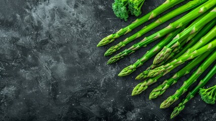  A arrangement of green asparagus on a black background, leaving room for text at the top