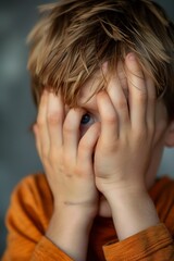 Boy peep closing his one eye in a protective position.