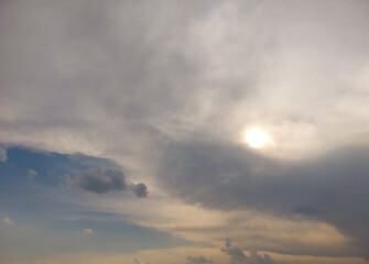 Fototapeta premium Beautiful blue sky background, sun hiding behind clouds over the field, nature photography