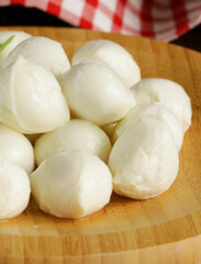 fresh organic mini mozzarella cheese on a wooden board