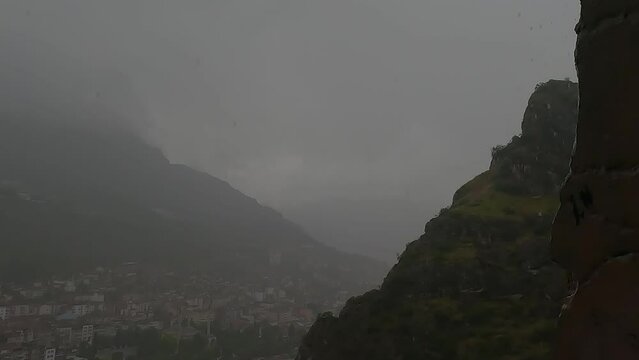 Rainy day in the mountains in Turkey. Rain and fog, mountains and houses, green plants and rain.