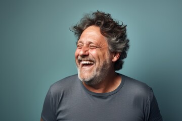 Obraz premium Portrait of a joyful man in his 50s laughing isolated in pastel gray background