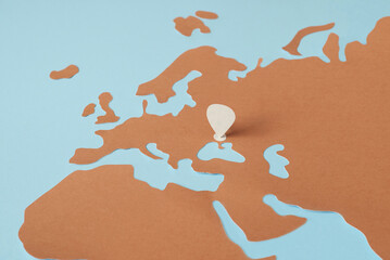 Location pin on Ukraine over paper world map.