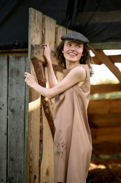 young smiling woman near a wooden barn