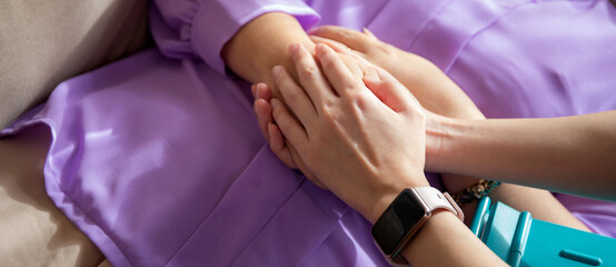 Closeup hands caregiver woman or doctor encourage and care senior while lying on sofa in living...